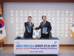 Belfast Lord Mayor and Sejong Mayor shaking hands and holding copies of the Innovation Twins Roadmap.